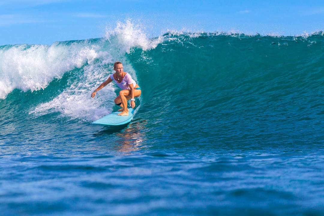 Surfer girl on Amazing Blue Wave, Bali island.Surfer girl on Amazing Blue Wave, Bali island.