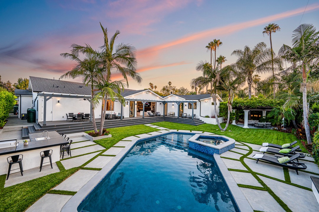 A backyard pool in a verdant garden setting in a modern new construction home in Los Angeles